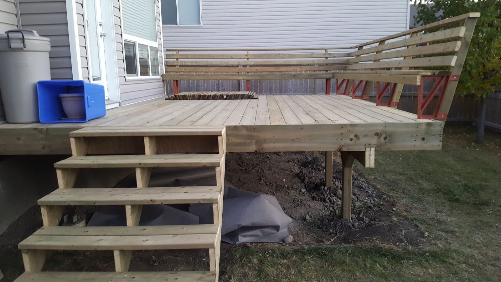 Deck framing carried on posts set into dug earth.