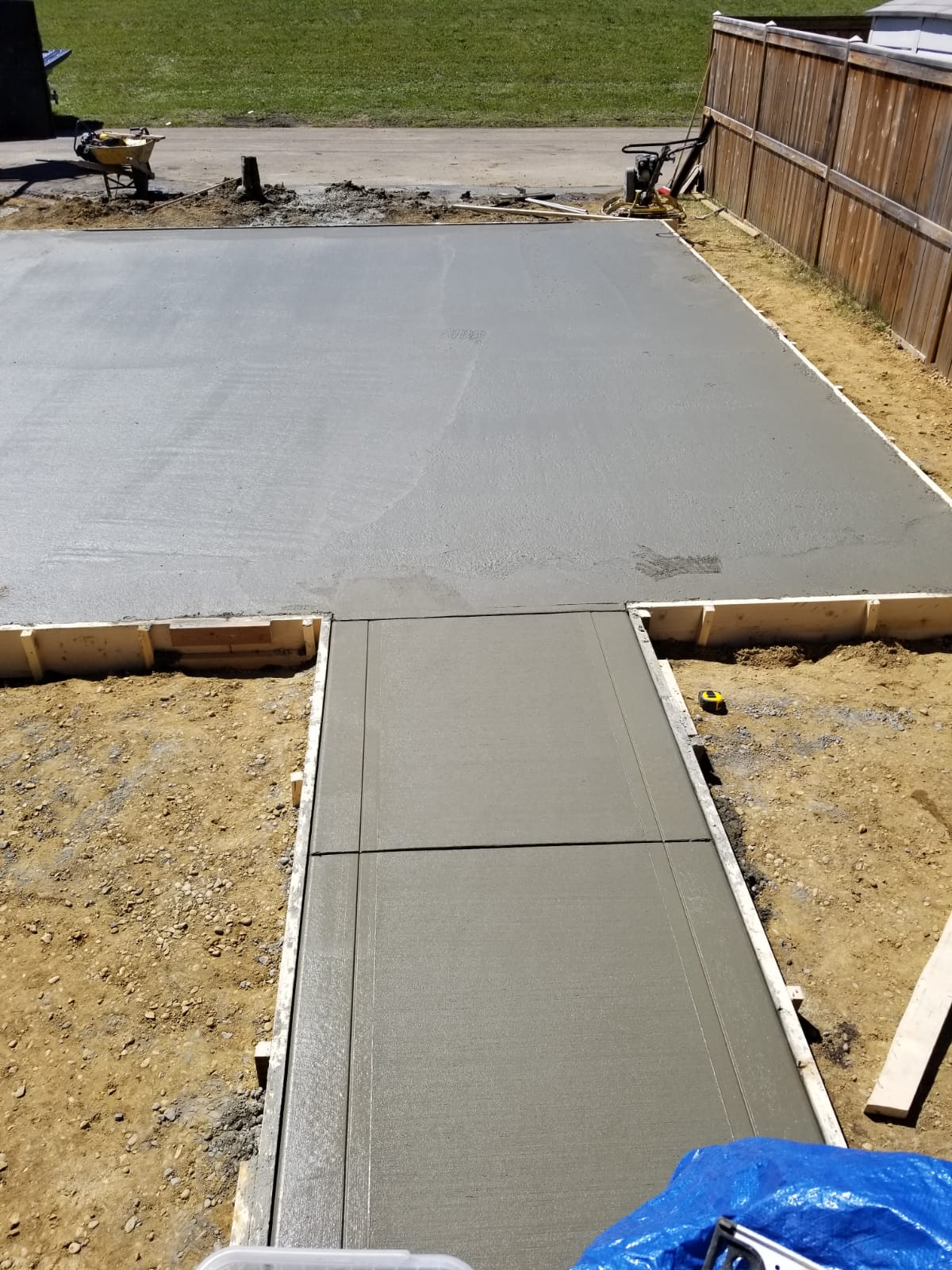 A poured concrete walk running through freshly dug soil.